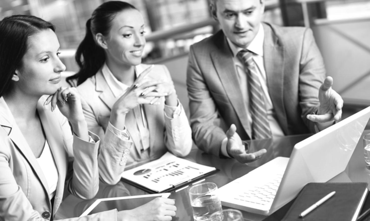 Business professionals analyzing financial charts and strategic planning documents during a collaborative workshop session